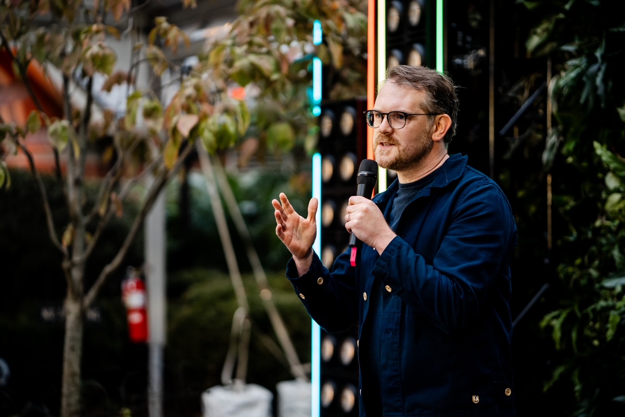 Photo of David McNair holding a mic presenting