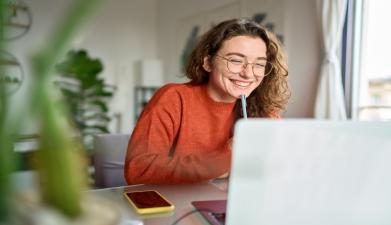 woman with glasses in frotn of computer screen