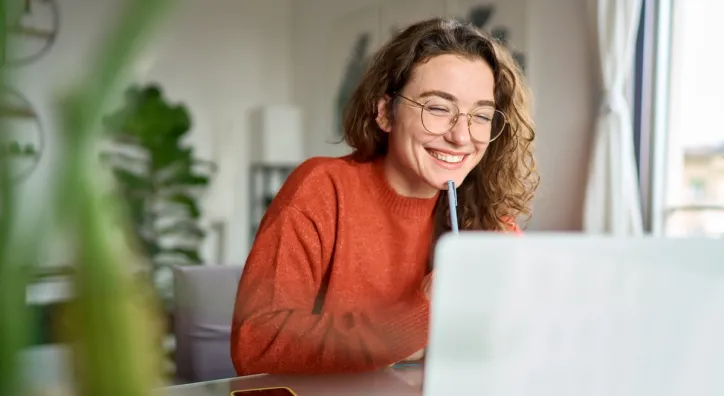 woman with glasses in frotn of computer screen